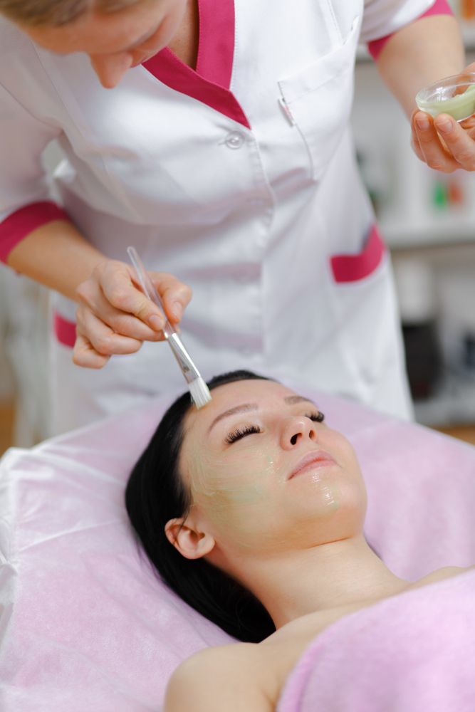 A pregnant woman receiving a safe facial treatment in Singapore.